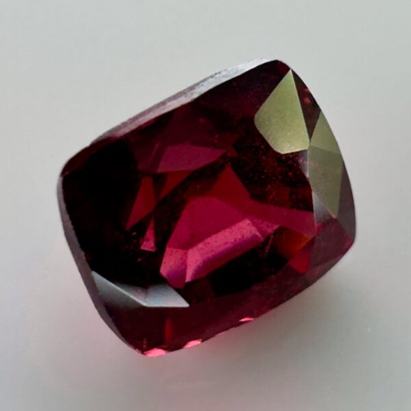 Natural cushion cut red spinel from Burma, exhibiting a rare raspberry color and excellent clarity, ideal for fine jewelry and gemstone collections.
