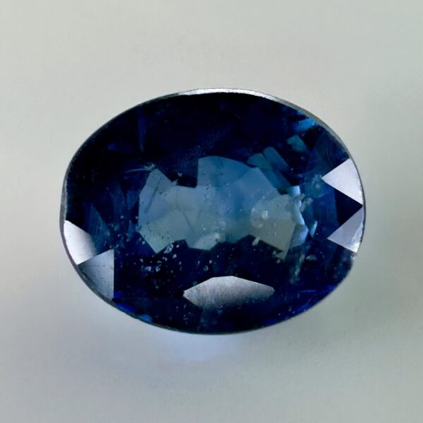 Natural blue sapphire 0.87 ct, oval cut, navy blue color, Thailand origin, jewelry quality gemstone with very few inclusions.